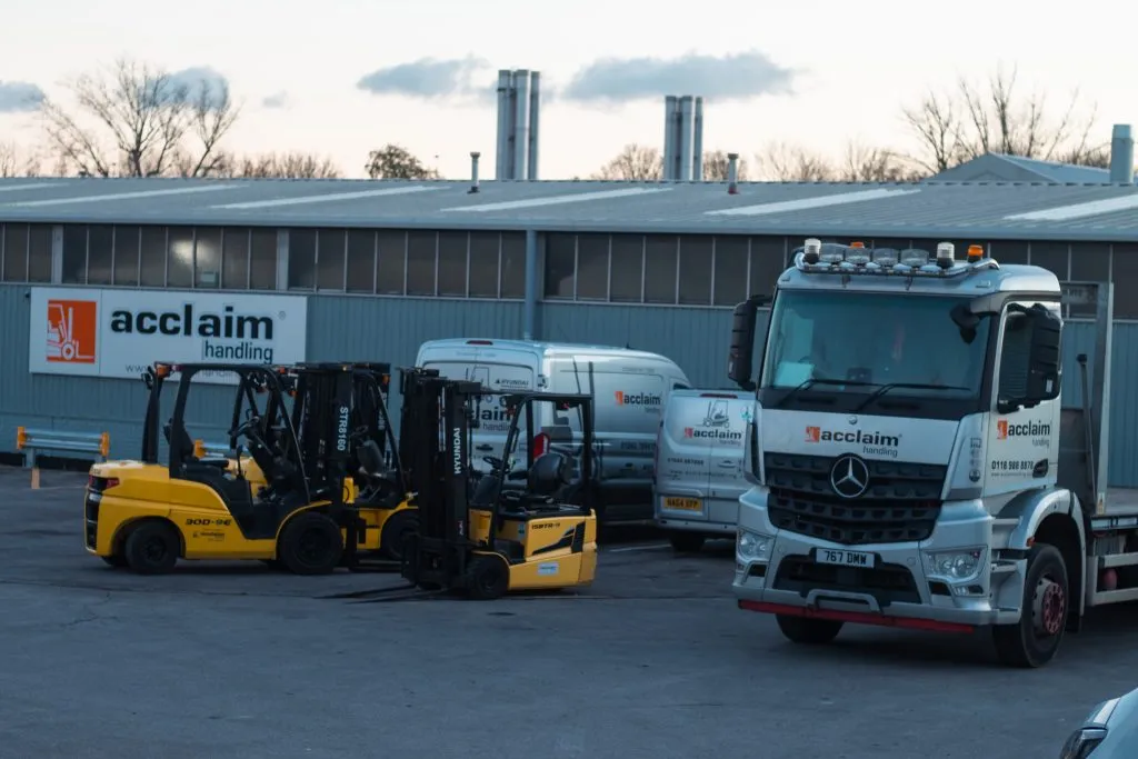 Forklifts lined up in an Acclaim Handling depot yard beside an Acclaim lorry