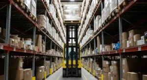 Forklift operating in a large warehouse aisle