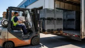 Forklift Driver Loading Stacked Pallet Crates Into Delivery Truck